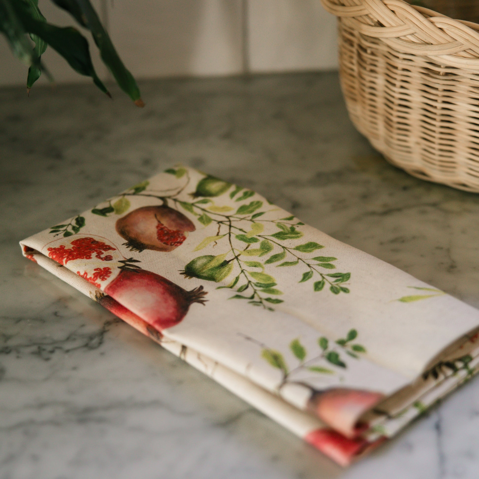 Floral-patterned fabric on a marble surface with a wicker basket in the background