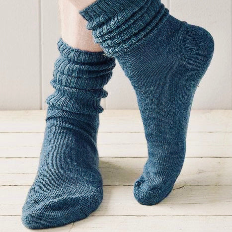 Blue ribbed socks worn on a light wooden floor.